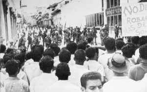 LA FOTO DE LA IZQUIERDA, TOMADA POCO ANTES DE QUE SE INICIARA LA MASACRE DEL 22 DE ENERO DE 1967 en las esquinas de los entonces bancos Central y Nacional. A la derecha, como es en la actualidad, sede de la Asamblea Nacional. Quedan algunos de los árboles de laurel de la india desde donde cayeron muertos muchos manifestantes. El primer muerto fue el teniente Sixto Pineda.